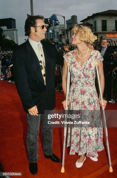 American actor Robert Davi, wearing a black jacket with a shirt and tie, and black jeans, and his wife Christine Bolster, who wears a floral pattern...