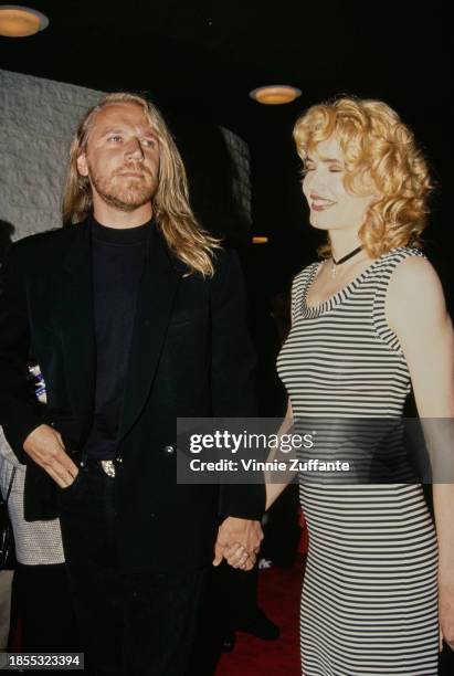 Finnish film director Renny Harlin, wearing a black suit, and American actress Geena Davis, wearing a hooped black-and-white dress, attend the...