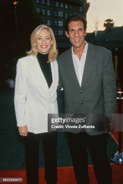 American actress Ally Walker, wearing a white jacket over a black turtleneck sweater with black trousers, and American actor Robert Davi, who wears a...