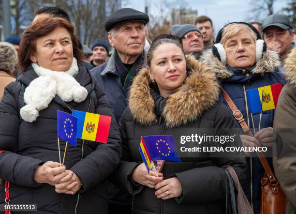 Attendees hold Moldovan national flags and the EU flag as they take part in a rally and open air concert in the courtyard of Moldovan Presidency...