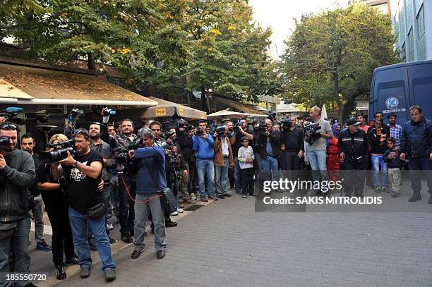 Broadcast and photoreporters wait outside the courthouse on October 21 in the central Greek city of of Larissa, where a Roma couple is due to appear...