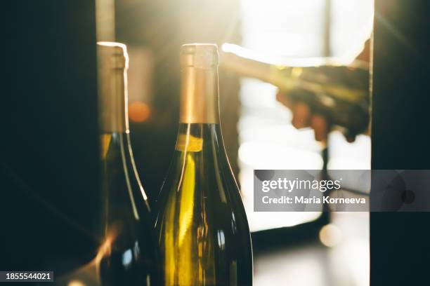 wine bottles on shelf at a winery. customer chooses wine at the winery. - wine rack stock pictures, royalty-free photos & images