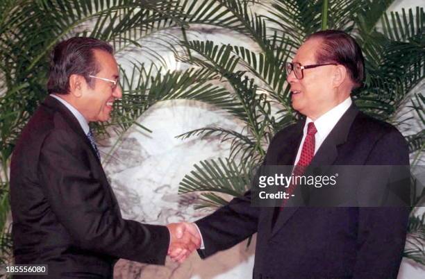 Chinese President Jiang Zemin shakes hands with visiting Malaysian Prime Minister Mahathir Mohamad 19 August 1999 in the Northeastern city of Dalian....