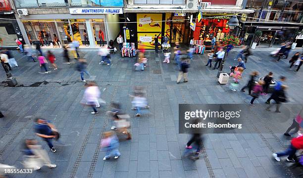 Pedestrians pass along a shopping street lined with retail stores in Belgrade, Serbia, on Sunday, Oct. 20, 2013. Serbia's government revealed a salvo...