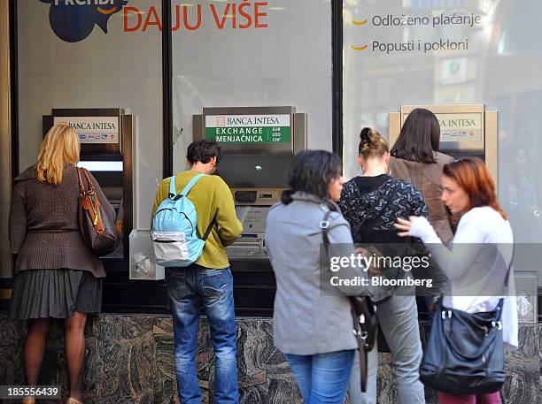Customers use automated teller machines outside a Banka Intesa SpA branch in Belgrade, Serbia, on Monday, Oct. 21, 2013. Serbia's government revealed...
