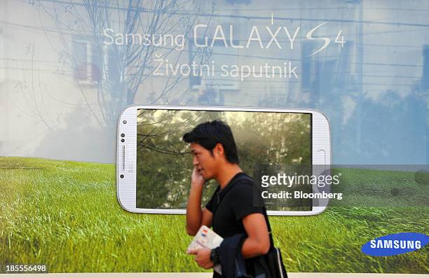 Pedestrian passes a Samsung Electronics Co. Ltd. Advertisement for the Galaxy S4 smartphone in Belgrade, Serbia, on Monday, Oct. 21, 2013. Serbia's...