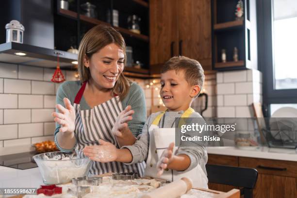 mother and son in aprons playing with dough - baking stock pictures, royalty-free photos & images