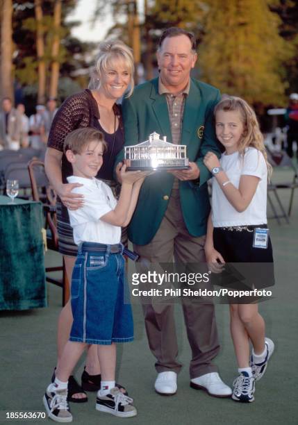 Mark O'Meara of the United States wearing the green jacket and holding the trophy with his wife Alicia, daughter Michelle and son Shaun after winning...