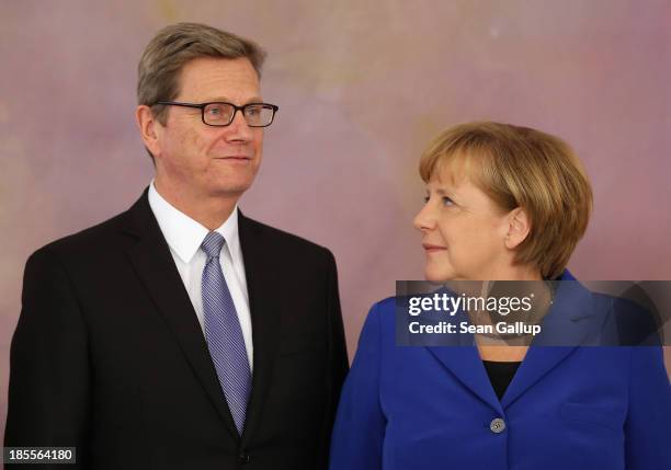 German Chancellor Angela Merkel looks at Foreign Minister Guido Westerwelle, who is a member of the German Free Democrats , after he received his...