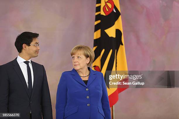 German Chancellor Angela Merkel looks at Vice Chancellor and Economy Minister Philipp Roesler, who is a member of the German Free Democrats , before...