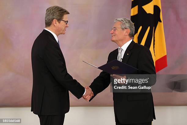 Outgoing German Foreign Minister Guido Westerwelle , who is a member of the German Free Democrats , receives his dismissal certificate from German...