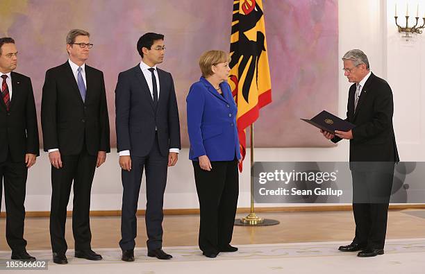 German President Joachim Gauck prepares to give outgoing German Chancellor Angela Merkel, as well as outgoing German Foreign Minister Guido...