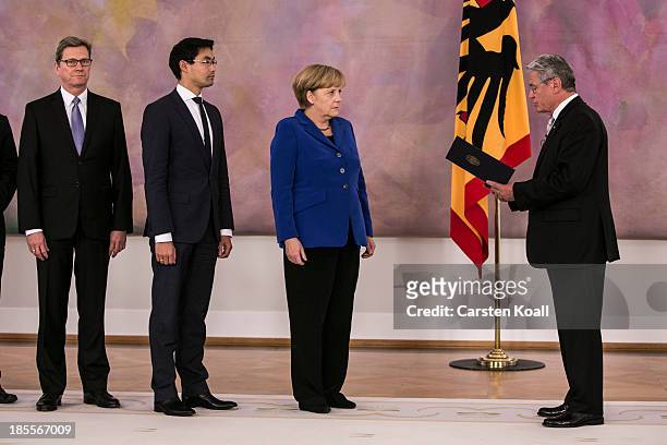 German President Joachim Gauck prepares to hand German Chancellor Angela Merkel her dismissal certificate at a ceremony for the outgoing German...