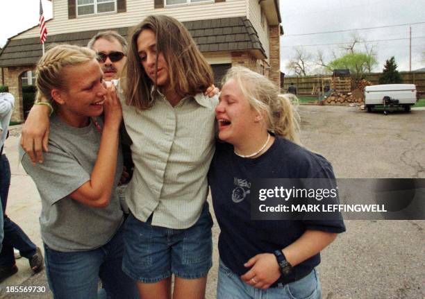 Two unidentified young people help another unidentified Columbine High School student to a bus after she escaped safely with other students from the...