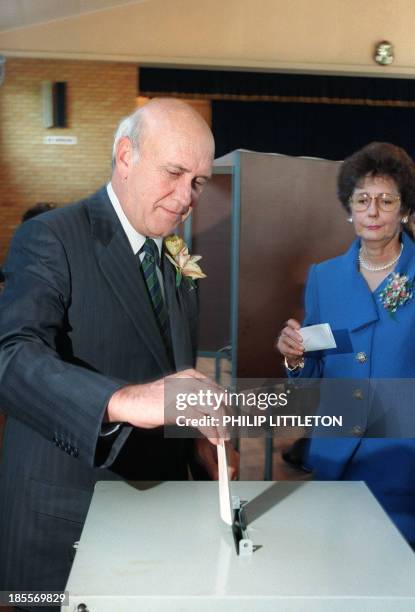 South African President Frederik Willem de Klerk casts his ballot as his wife Marike waits her turn at the polling station on April 27, 1994 in...