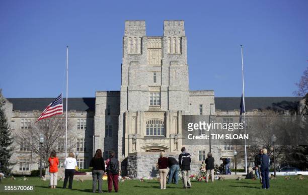 Flag flies at half staff outside Burruss Hall 20 April, 2007 on the campus of Virginia Tech in Blacksburg, Virginia. Bells were set to toll in the...