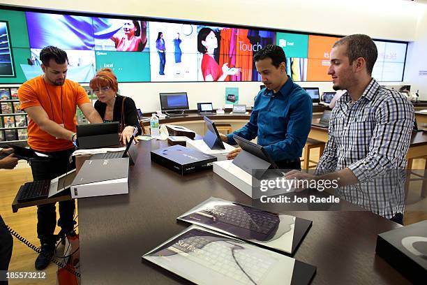 Microsoft Product Advisor Brandon Rupp helps J. Morales with her new Microsoft Surface Pro 2 tablet as she and other customers purchase them at a...