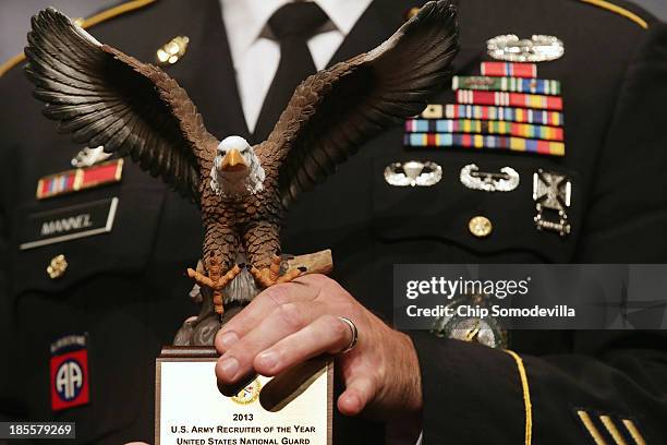 United States Army Sgt. 1st Class Joshua Mannel holds his trophy for being the Army Reserves Recruiter of the Year during Dwight David Eisenhower...