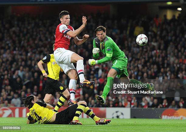 Olivier Giroud of Arsenal challenges goalkeeper Roman Weidenfeller of Dortmund on his was to scoring for Arsenal during the UEFA Champions League...
