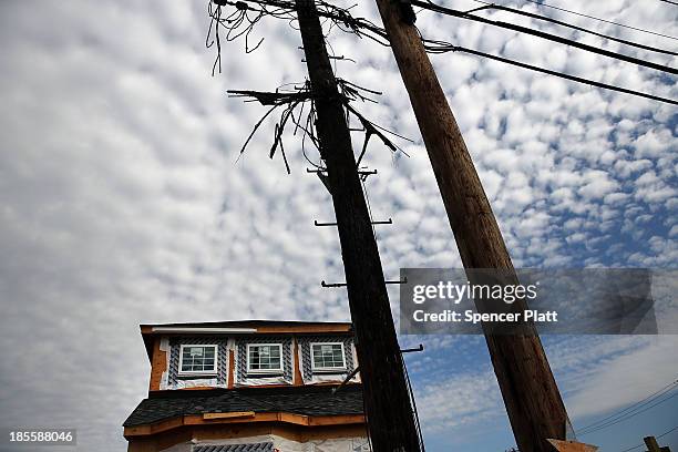 Charred pole stands near a new home constructed in an area that was heavily damaged by fire in Hurricane Sandy on October 22, 2012 in the Breezy...