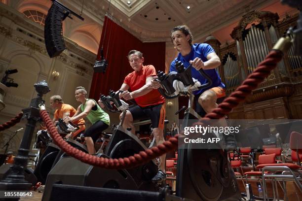 Contestants cycle during a spinning marathon in the Concertgebouw concert hall in Amsterdam on October 22 during an event aimed at raising money for...