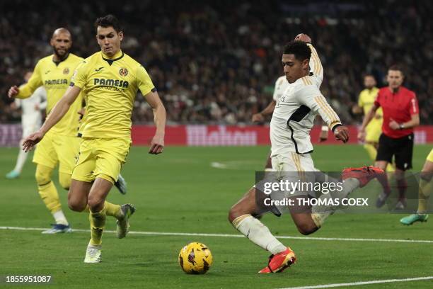 Villarreal's Algerian defender Aissa Mandi challenges Real Madrid's English midfielder Jude Bellingham as he shoots the ball during the Spanish...
