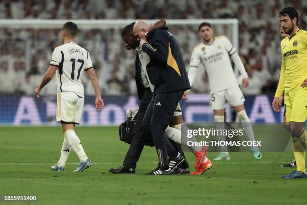 Real Madrid's Austrian defender David Alaba is helped to leave the pitch after resulting injured during the Spanish league football match between...
