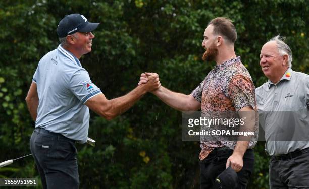 Matt Kuchar shakes hands with Shaun O'Meara and his father, Mark O'Meara, on the ninth green during the first round of the PNC Championship at The...