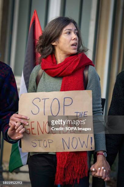 An activist holds a placard in favor of a ceasefire in the Gaza Strip during a demonstration in front of the Israeli embassy. The protest actions...