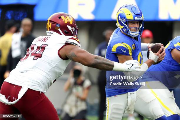 Los Angeles Rams quarterback Matthew Stafford avoids a tackle by Washington Commanders defensive tackle Daron Payne during the first half at SoFi...