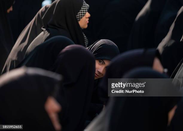Veiled Iranian woman is looking on while attending a religious ceremony to commemorate the death anniversary of Fatima, the daughter of Prophet...