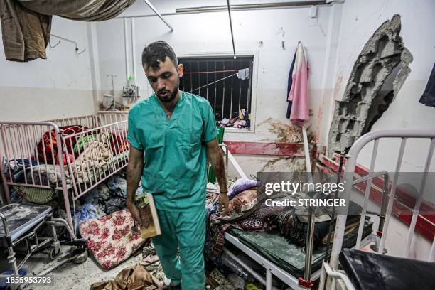 Man inspects the damage in a room following Israeli bombardment at Nasser hospital in Khan Yunis in the southern Gaza Strip on December 17 amid...