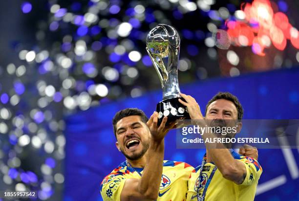 America's Mexican forward Henry Martin and America's Mexican defender Miguel Layun celebrate with the trophy after winning the Mexican Apertura...