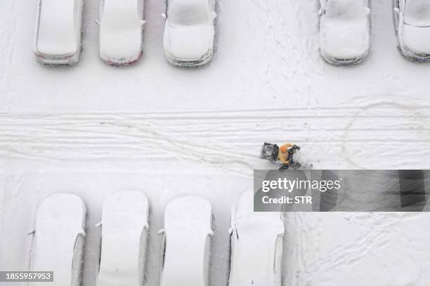 In this photo taken on December 16 a delivery rider delivers food during a snowfall in Yantai, in China's eastern Shandong province. / China OUT