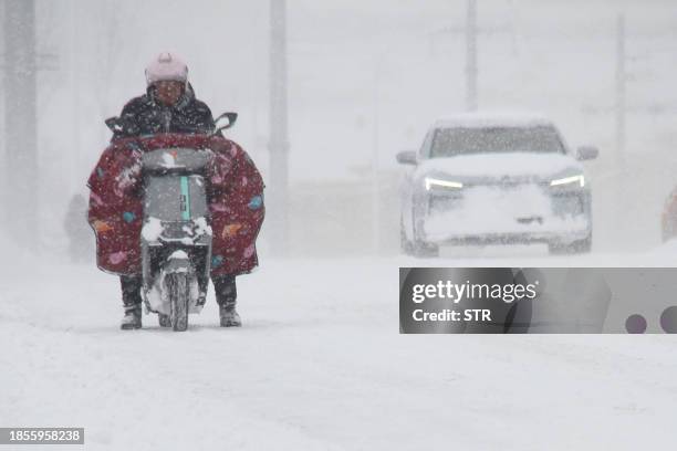 In this photo taken on December 16 motorists negotiate a road during a snowfall in Weihai, in China's eastern Shandong province. / China OUT