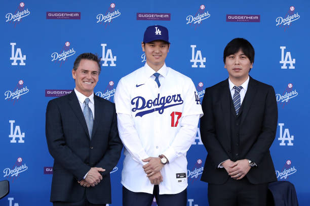 Shohei Ohtani poses for a photo with his interpreter Ippei Mizuhara and agent Nez Balelo after being introduced by the Los Angeles Dodgers at Dodger...