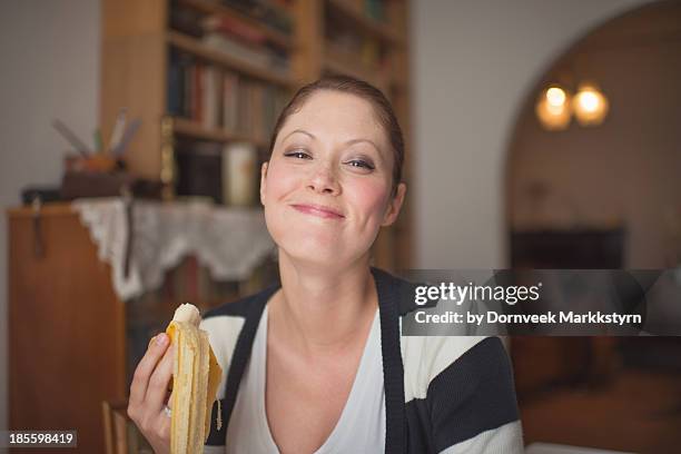 happy girl eating banana - banane essen stock-fotos und bilder