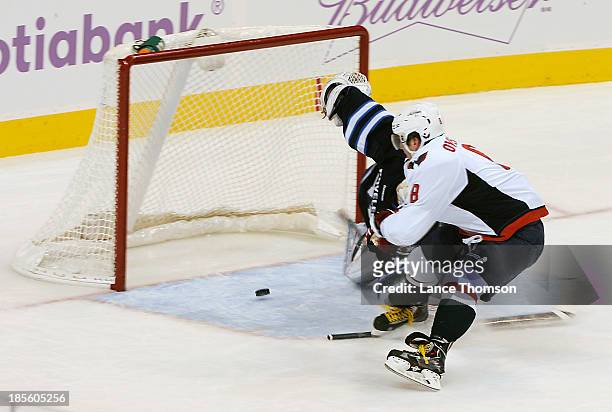 Alex Ovechkin of the Washington Capitals slides the puck in behind goaltender Ondrej Pavelec of the Winnipeg Jets during second period action at the...