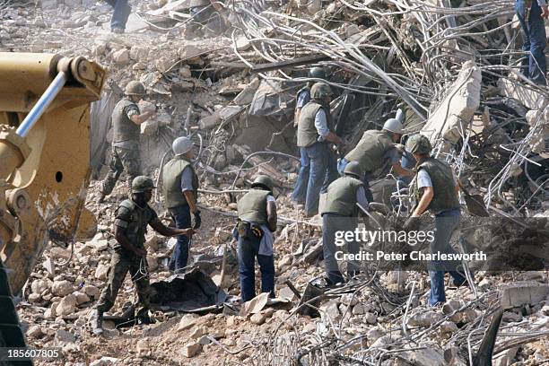 American Marines search for survivors and bodies in the rubble, all that was left of their barracks head quarters in Beirut, after a terrorist...