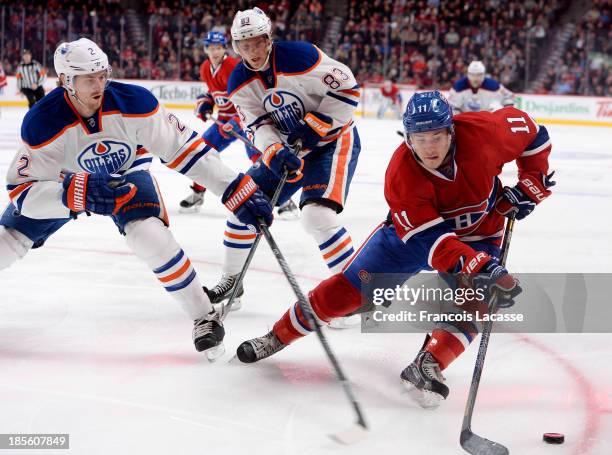 Brendan Gallagher of the Montreal Canadiens controls the puck while being challenged by Jeff Petry and Ales Hemsky of the Edmonton Oilers during the...