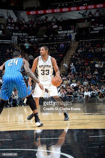 Boris Diaw of the San Antonio Spurs handles the ball against Romero Osby of the Orlando Magic during the first preseason game at the AT&T Center on...
