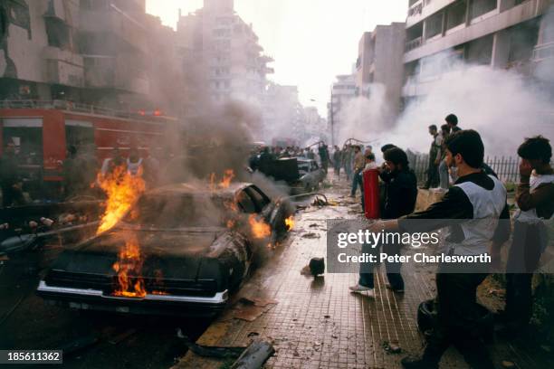 Civil defence volunteers, firemen and passers-by try to help rescue victims and put out fires caused by a massive car bomb, detonated in a main...