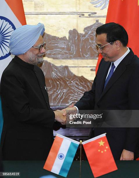 Indian Prime Minister Manmohan Singh shakes hands with Chinese Premier Li Keqiang after a joint news conference at the Great Hall of the People on...