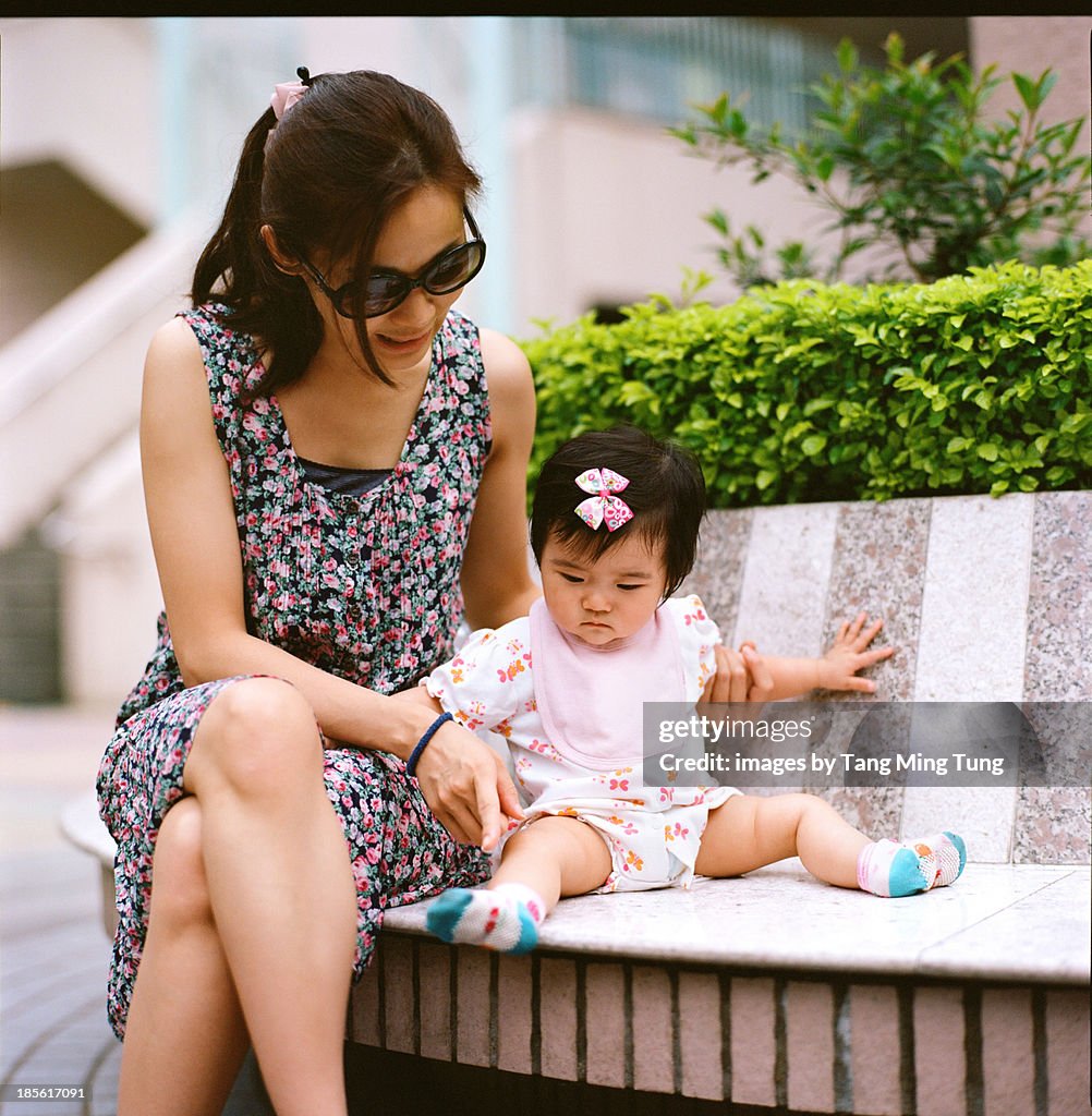 Mom & baby sitting & talking on stone bench