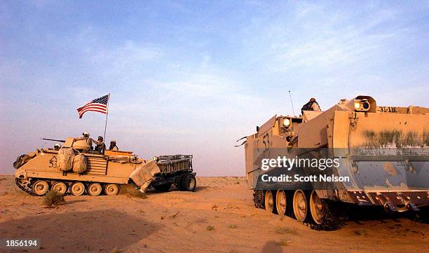 Army 11th Engineers 113 moves past an armoured combat earth mover into position near the Iraqi border in Kuwait ahead of a possible military strike...