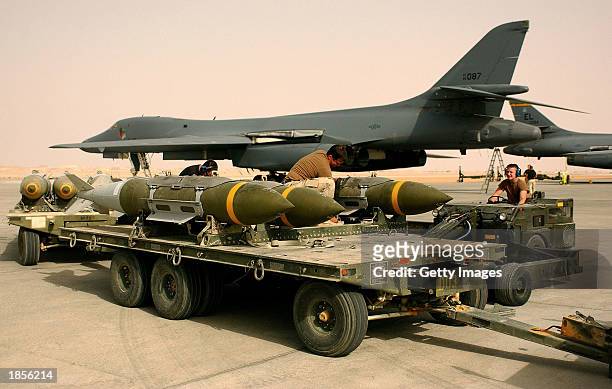 This handout image shows members of the 405th Air Expeditionary Wing preparing to load twelve 2,000-pound bombs and "bunker buster" bombs onto a B-1...