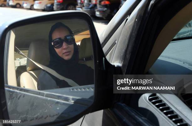 Saudi activist Manal Al Sharif, who now lives in Dubai, drives her car in the Gulf Emirate city on October 22 as she campagins in solidarity with...