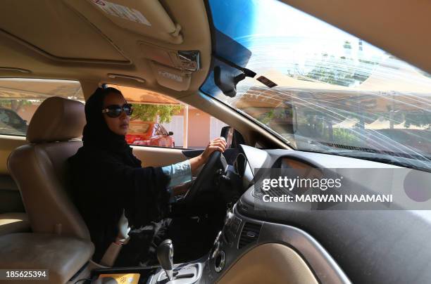 Saudi activist Manal Al Sharif, who now lives in Dubai, drives her car in the Gulf Emirate city on October 22 as she campagins in solidarity with...