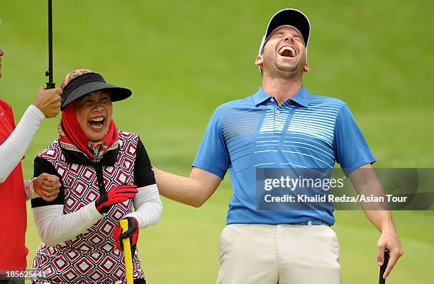 Sergio Garcia of Spain and Queen Tuanku Hajah Haminah of Malaysia share a joke during practice ahead of the CIMB Classic at Kuala Lumpur Golf &...