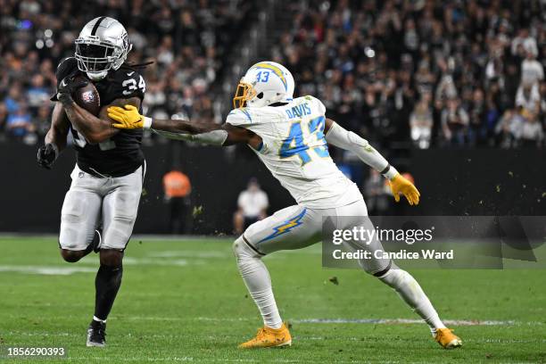 Running back Brandon Bolden of the Las Vegas Raiders rushes past cornerback Michael Davis of the Los Angeles Chargers before scoring a touchdown...
